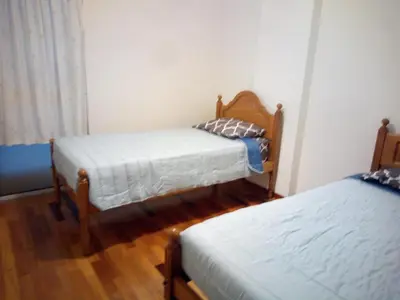 two beds in a room with wooden floors at Costa Lodges, Funchal or Santa Cruz in Santa Cruz