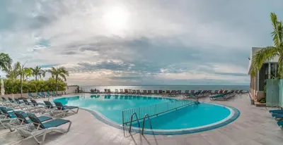 a pool with chairs and the ocean in the background at Duas Torres View Apartment in Funchal