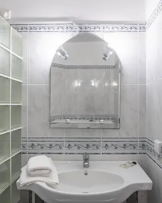 a white bathroom with a sink and a mirror at Duas Torres View Apartment in Funchal
