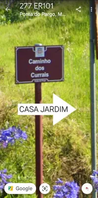 a sign on a pole in a garden at Casa Jardim in Ponta do Pargo