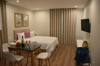 a hotel room with a bed and a table and chairs at Vicente´s LOB ( Lobos Ocean Breeze) in Câmara de Lobos