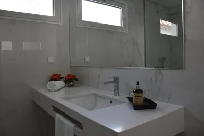 a white bathroom with a sink and a mirror at Vicente´s LOB ( Lobos Ocean Breeze) in Câmara de Lobos