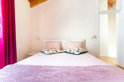 a white bed with two pillows on top of it at Casa Hortas in Vila do Bispo