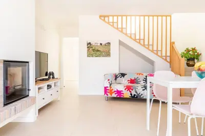 a living room with a tv and a table and a couch at Casa Hortas in Vila do Bispo