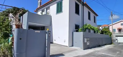 a white house with a gate in front of it at Achada Sol in Funchal