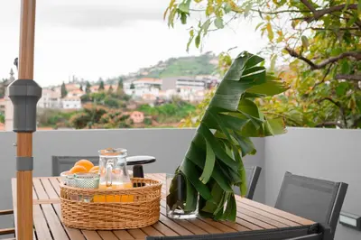 a table with a basket of fruit and a plant at Achada Sol in Funchal