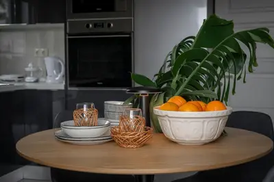 a table with a bowl of oranges and a plant at Achada Sol in Funchal