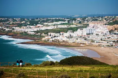 two people standing on a hill overlooking a beach at Casas da Calheta in Praia da Luz in Luz