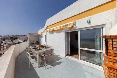 a patio with a table and chairs on a balcony at Casas da Calheta in Praia da Luz in Luz
