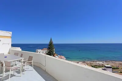 a balcony with a table and chairs and the ocean at Casas da Calheta in Praia da Luz in Luz