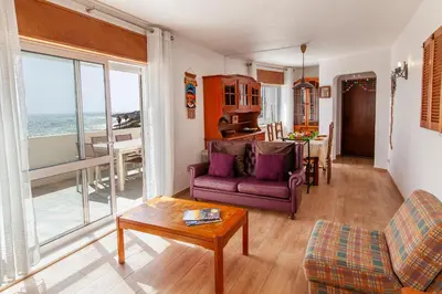 a living room with a purple couch and a table at Casas da Calheta in Praia da Luz in Luz