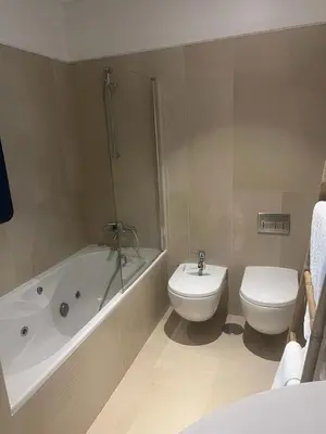 a bathroom with a toilet and a tub and a sink at Plaza Funchal - Coração da cidade in Funchal