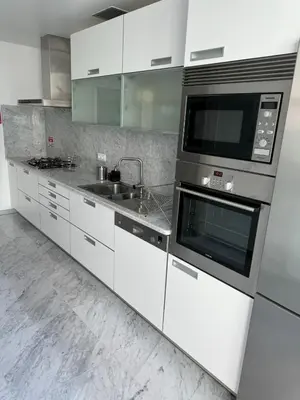 a kitchen with white cabinets and a microwave at Plaza Funchal - Coração da cidade in Funchal