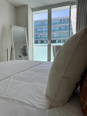 a bedroom with a white bed with a large window at Plaza Funchal - Coração da cidade in Funchal