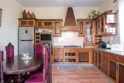 a large kitchen with wooden cabinets and a table at GuestReady - Tranquil Spot in São Vicente in São Vicente