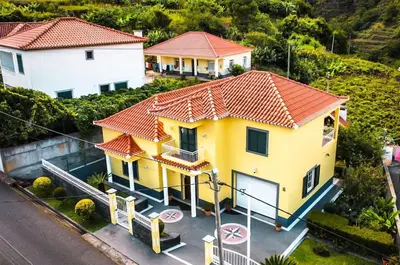 a yellow house with a red roof at GuestReady - Tranquil Spot in São Vicente in São Vicente