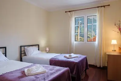 a hotel room with two beds and a window at GuestReady - Tranquil Spot in São Vicente in São Vicente