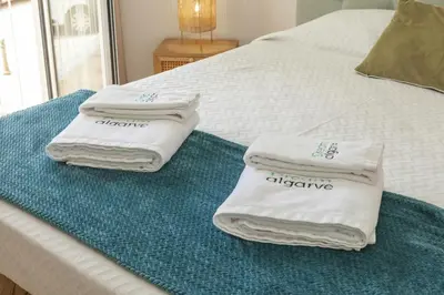 three towels are sitting on top of a bed at A18 - Luz Studio in Praia da Luz in Luz