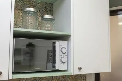 a microwave oven in a kitchen with glass jars at A18 - Luz Studio in Praia da Luz in Luz