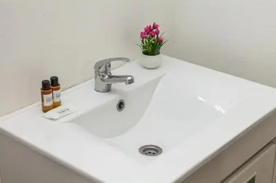 a white sink with a vase of flowers on it at A18 - Luz Studio in Praia da Luz in Luz