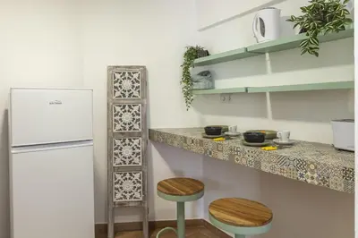 a kitchen with a counter and a refrigerator and two stools at A18 - Luz Studio in Praia da Luz in Luz