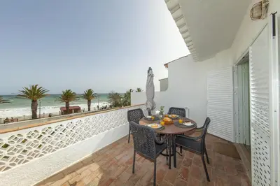 a balcony with a table and chairs and the beach at B86 - Beachline Apartment in Praia da Luz in Luz