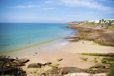 a beach with people swimming in the water at B86 - Beachline Apartment in Praia da Luz in Luz