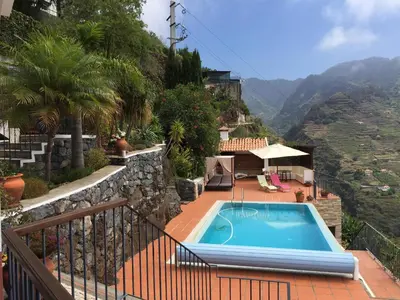 a swimming pool on the side of a house at Villa Tabua in Ribeira Brava