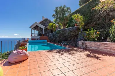 a house with a swimming pool on a brick patio at Villa Tabua in Ribeira Brava