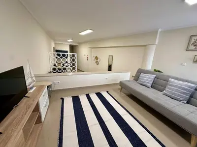 a living room with a couch and a flat screen tv at Olá Mar in Santa Cruz