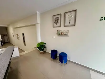a room with two blue stools and a white wall at Olá Mar in Santa Cruz