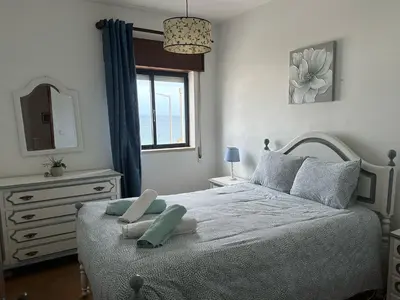 a bedroom with a bed with a mirror and a window at Casa do Mar in Salema