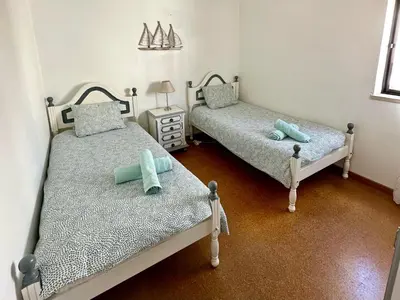 two twin beds in a room with a lamp at Casa do Mar in Salema