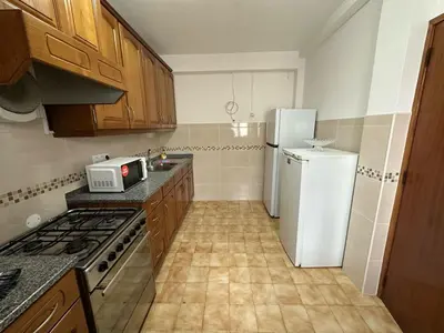 a kitchen with a white refrigerator and a stove at Casa do Mar in Salema