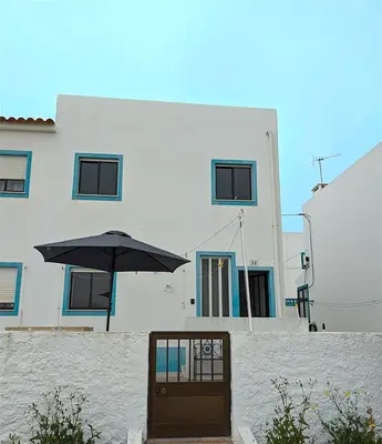 a door with an umbrella in front of a building at Casa do Mar in Salema