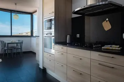 a kitchen with a stove and a table in it at GuestReady - A splendid sea-view stay in Caniço