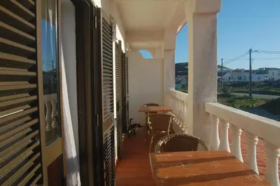 a balcony of a house with a table and chairs at CASA DA HORTA in Aljezur
