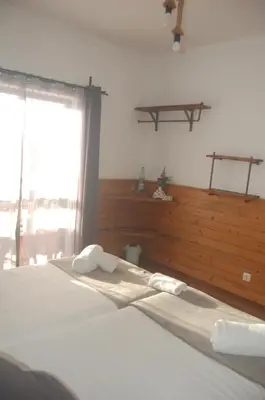 a bedroom with a bed with white sheets and a window at CASA DA HORTA in Aljezur