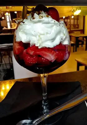 a dessert with strawberries and whipped cream in a glass at CASA DA HORTA in Aljezur
