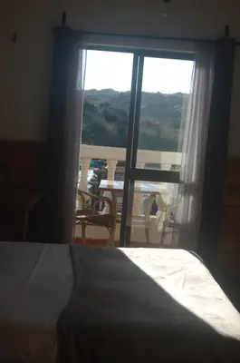 a bedroom with a bed and a view of a table at CASA DA HORTA in Aljezur