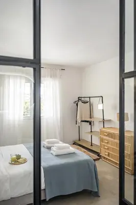 a bedroom with a bed and a dresser with towels on it at Casa do Cacto - By WeHost in Porto Santo