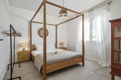 a bedroom with a four poster bed and a window at Casa do Cacto - By WeHost in Porto Santo
