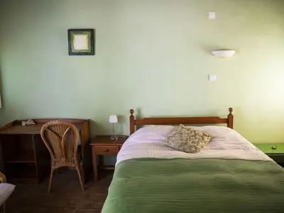 a bedroom with a bed with a table and a chair at Monte Rosa Rural Guesthouse in Lagos