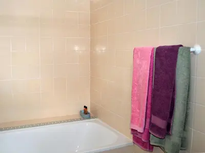 a bathroom with a bath tub with pink and purple towels at Monte Rosa Rural Guesthouse in Lagos