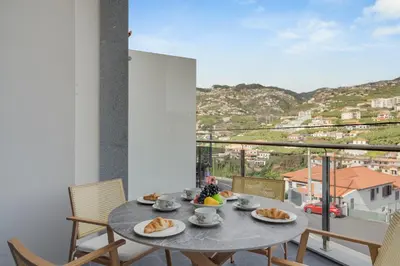 a table with plates of food on top of a balcony at Torre Palace I by Atlantic Holiday in Câmara de Lobos