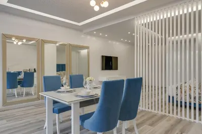 a dining room with a white table and blue chairs at Torre Palace I by Atlantic Holiday in Câmara de Lobos