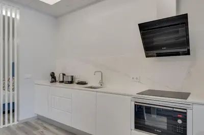 a white kitchen with a sink and a microwave at Torre Palace I by Atlantic Holiday in Câmara de Lobos