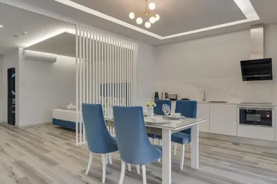 a dining room with a table and blue chairs at Torre Palace I by Atlantic Holiday in Câmara de Lobos