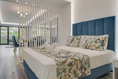 a bedroom with a large bed with a blue headboard at Torre Palace II by Atlantic Holiday in Câmara de Lobos