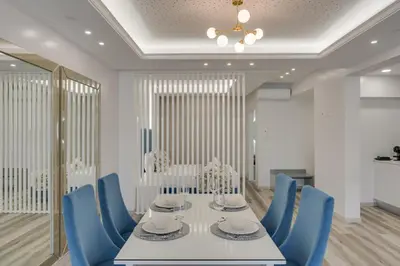 a dining room with a white table and blue chairs at Torre Palace II by Atlantic Holiday in Câmara de Lobos